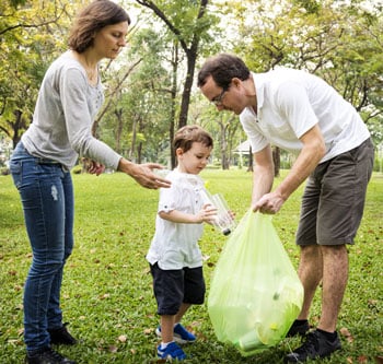 Family picking up litter in the park