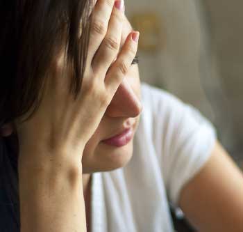 Woman covering her eyes and looking very stressed