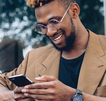 Smiling man on bench using smartphone