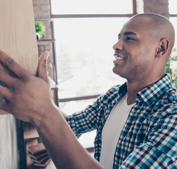 Man hanging a shelf in his home