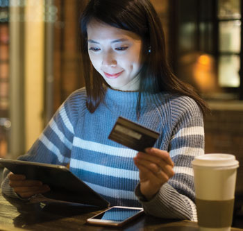 Woman using credit card to buy something on her tablet