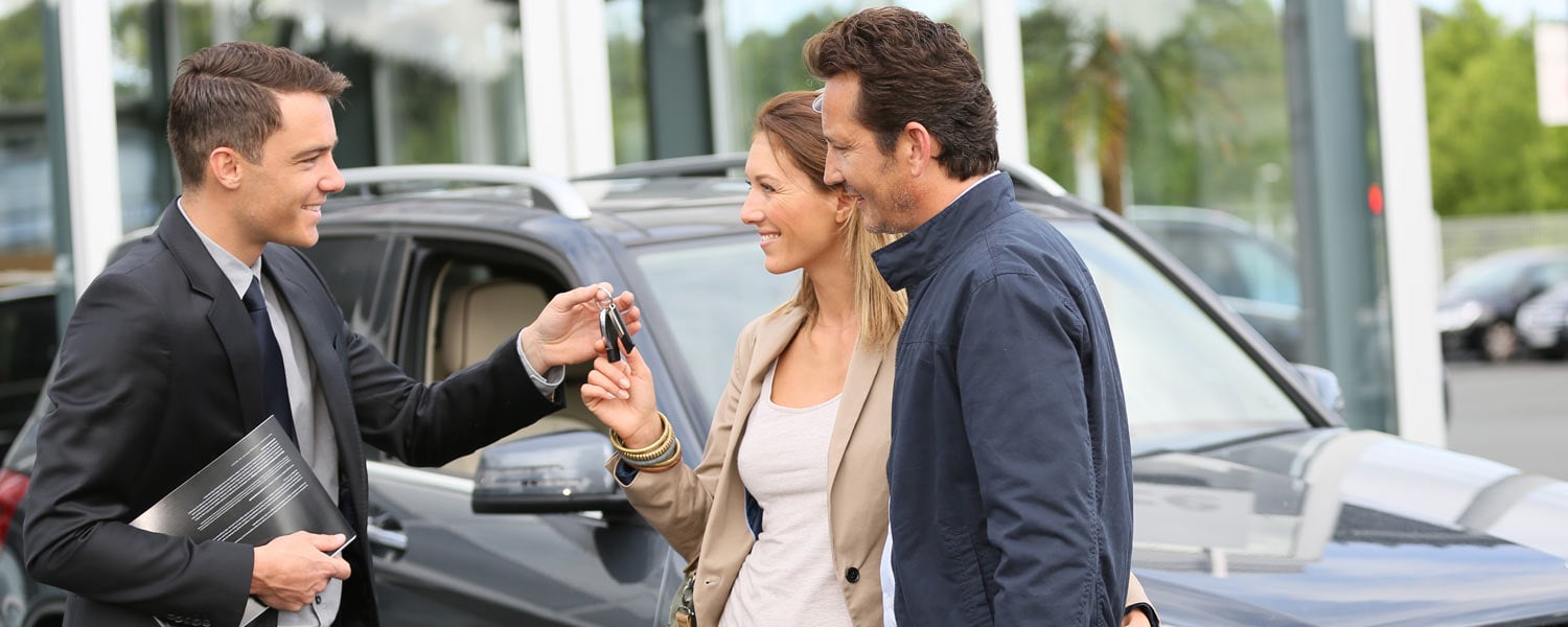 Couple at car dealer taking keys