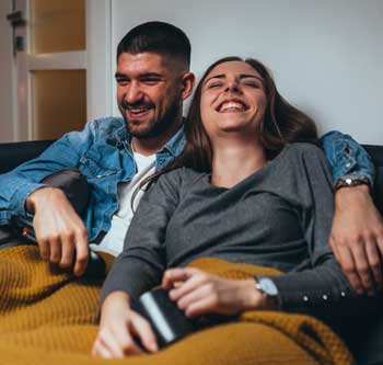 Couple laughing together under a blanket