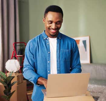 Man in jean jacket packing up boxes