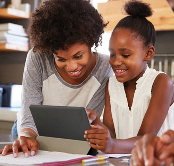 Family smiling and sharing tablet in kitchen