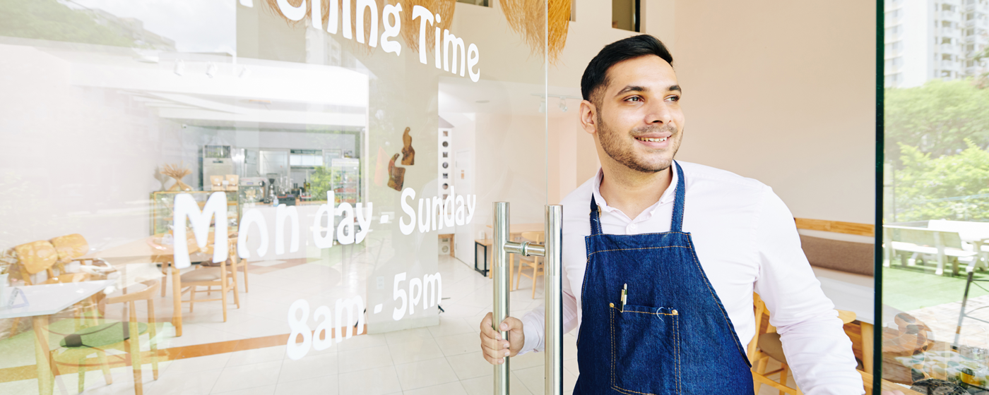 Man with apron opening the door