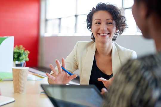 Woman in suit jacket helping couple open a checking account