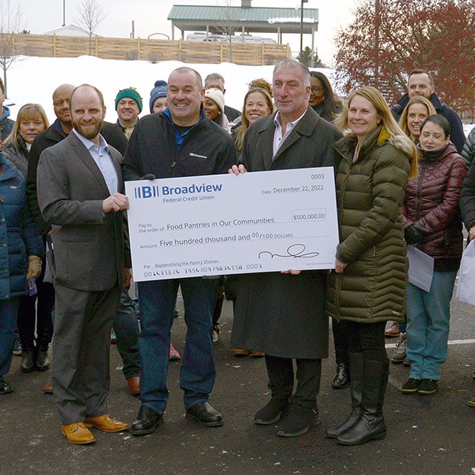 Chris and Michael holding up food pantry check