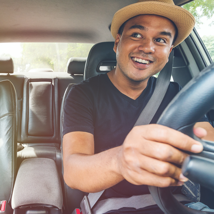 Man holding steering wheel and smiling