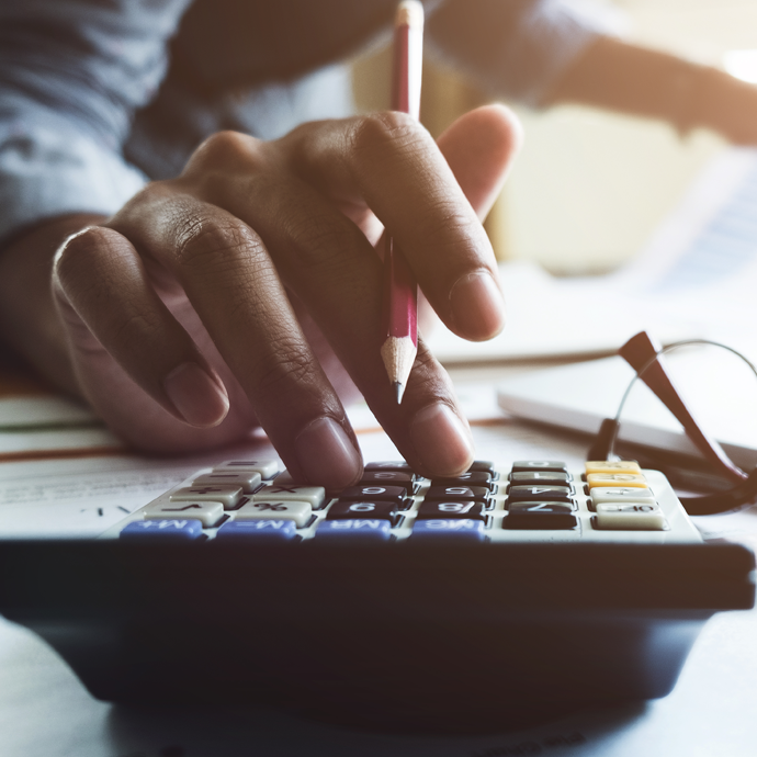 Person holding pencil and using calculator