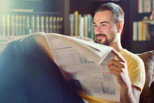 Man in yellow shirt reading the newspaper