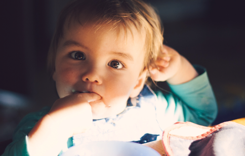 Young child with finger in their mouth