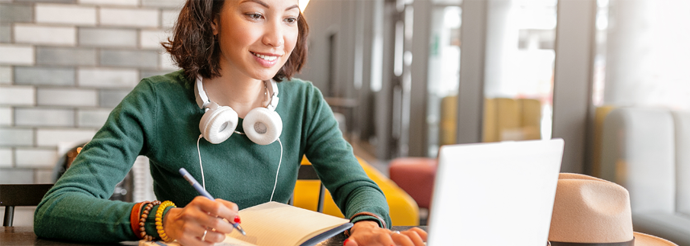 Young woman wearing headphones and working at a computer