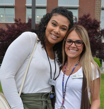 Two female CAP COM employees outside posing for a picture
