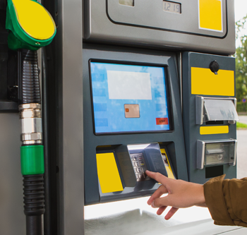 A person putting a debit card into a gas station pump to pay
