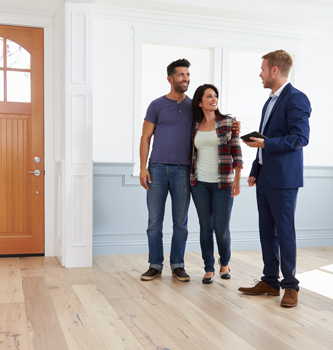 A couple looking at a house with a realtor.