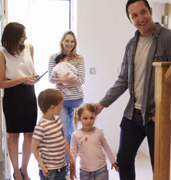 Family walking into home with agent