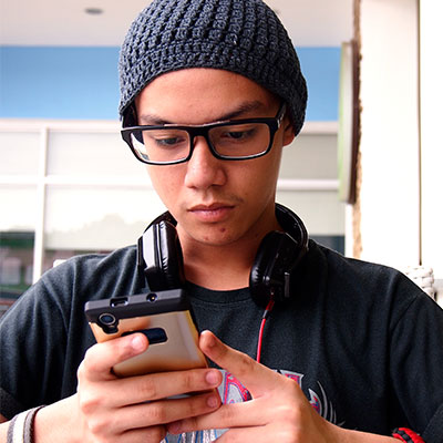Man wearing beanie and looking at his phone