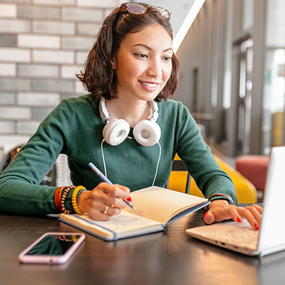 Woman wearing headphones and looking at her computer